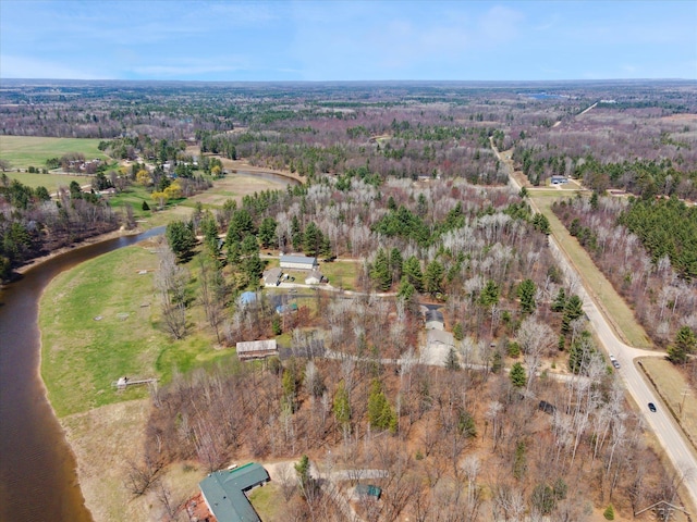 birds eye view of property featuring a forest view and a water view