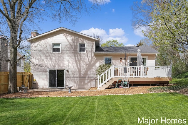 back of house featuring a yard, fence, a wooden deck, and a chimney