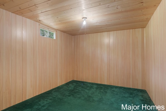 carpeted empty room featuring wood walls and wooden ceiling
