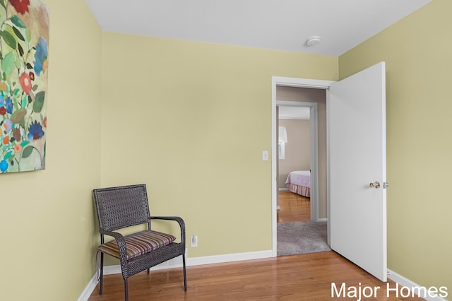 living area with baseboards and wood finished floors