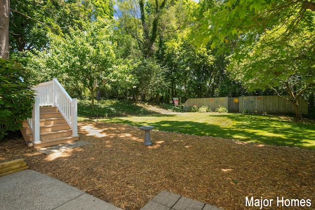 view of yard featuring fence and stairway