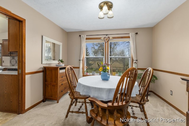 dining room featuring baseboards and light colored carpet