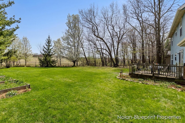 view of yard featuring a garden and a wooden deck