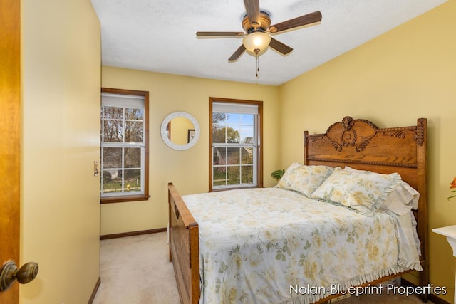 bedroom featuring baseboards, ceiling fan, and light carpet
