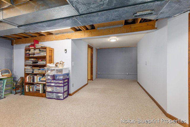 finished below grade area featuring baseboards and carpet
