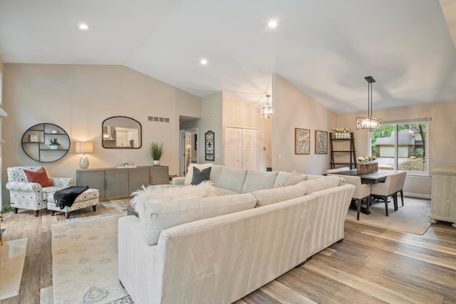 living area with a notable chandelier, recessed lighting, wood finished floors, lofted ceiling, and visible vents