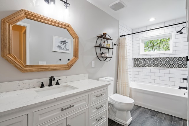 full bath with shower / bath combo with shower curtain, wood finished floors, toilet, and vanity