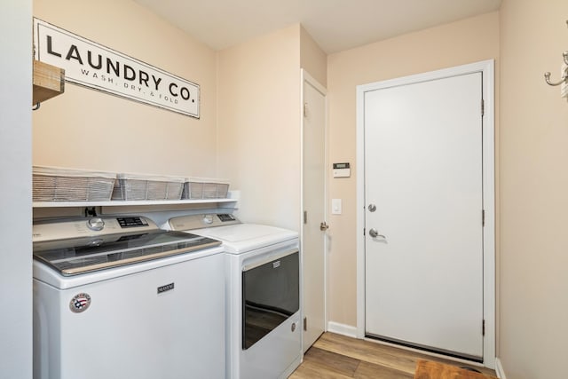 laundry room with laundry area, light wood-style flooring, and washing machine and clothes dryer