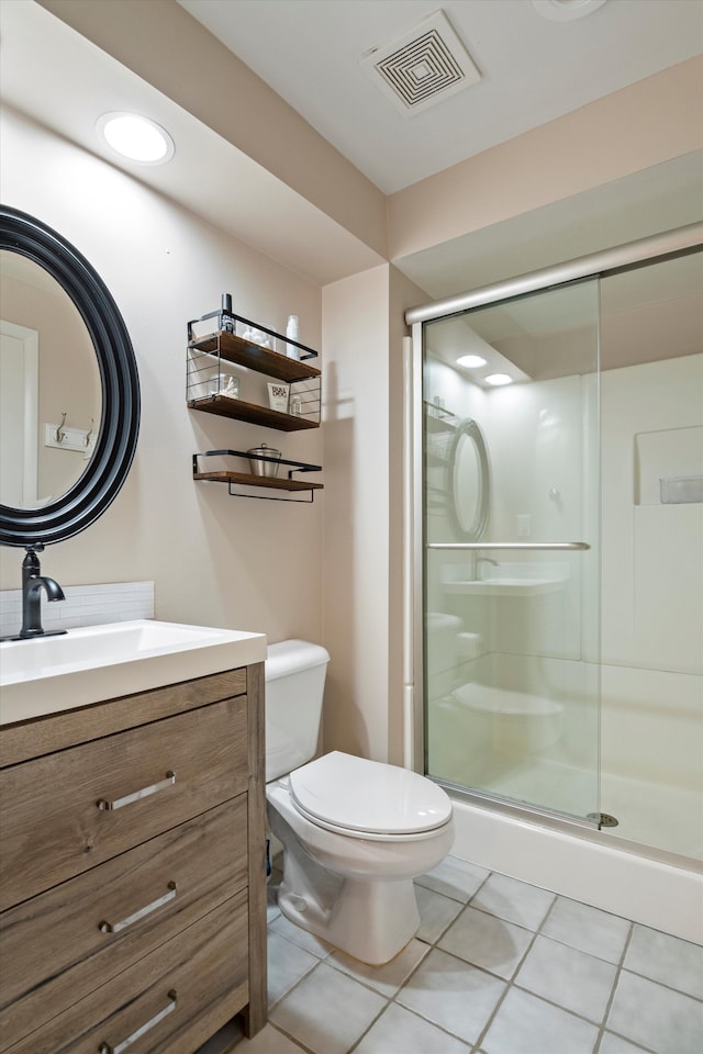 bathroom with vanity, toilet, tile patterned floors, a shower stall, and visible vents