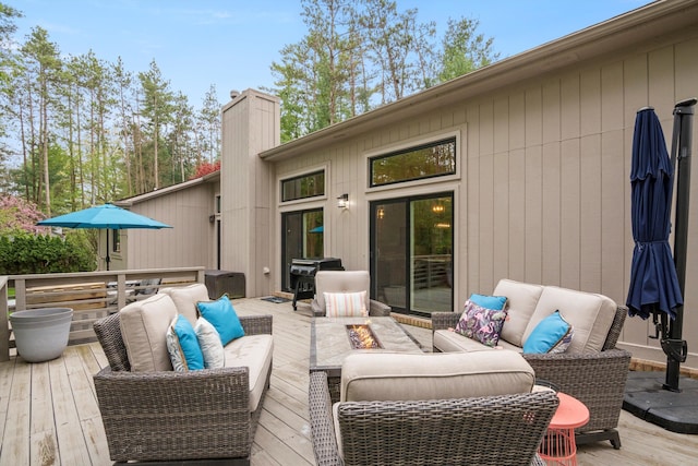 deck featuring an outdoor living space with a fire pit and a grill