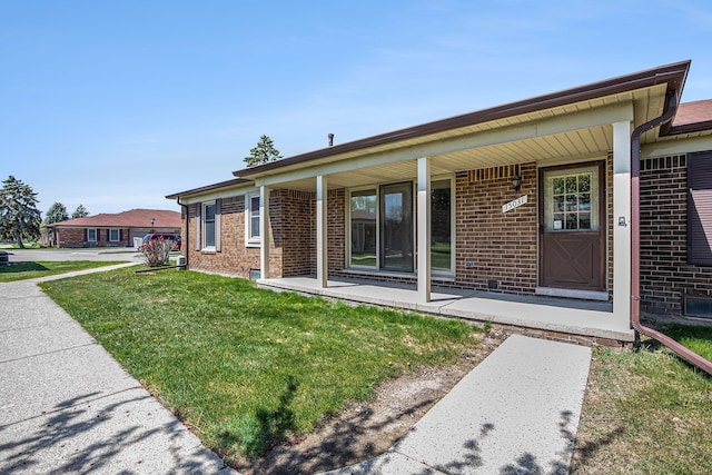 view of front facade featuring brick siding, a front lawn, and covered porch