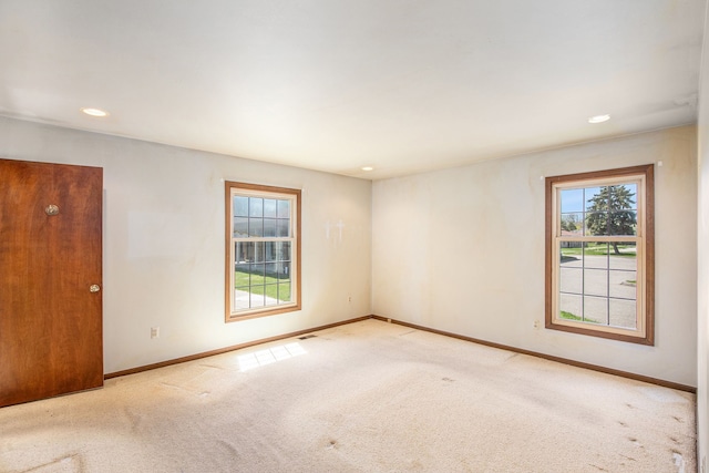empty room featuring recessed lighting, baseboards, and carpet