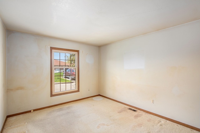 carpeted empty room featuring visible vents and baseboards