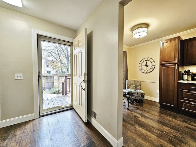doorway to outside featuring crown molding, baseboards, visible vents, and dark wood-type flooring