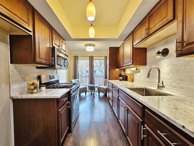 kitchen featuring decorative backsplash, dark wood-style flooring, light stone countertops, a sink, and appliances with stainless steel finishes