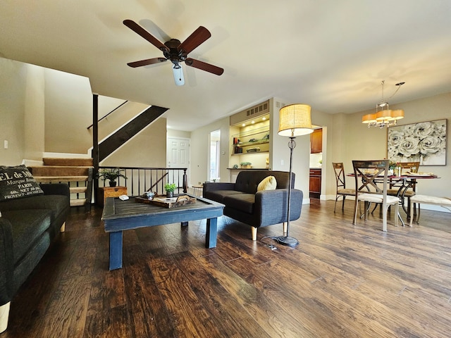 living area featuring stairway, baseboards, ceiling fan, and wood finished floors