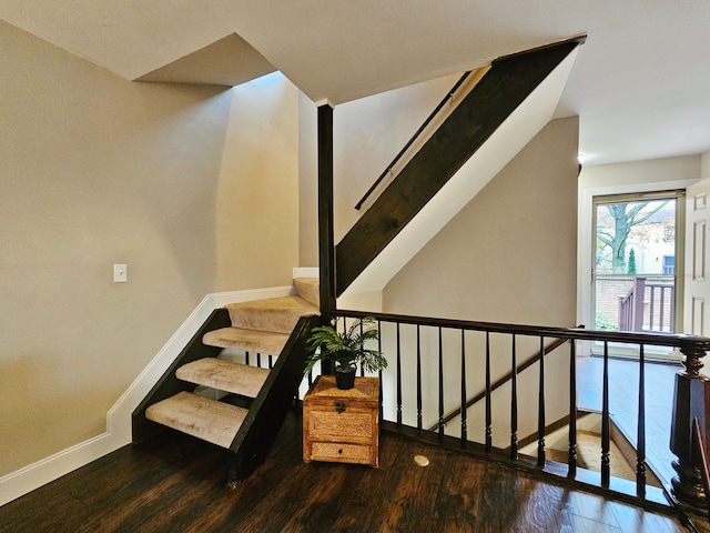 stairway with baseboards and wood finished floors