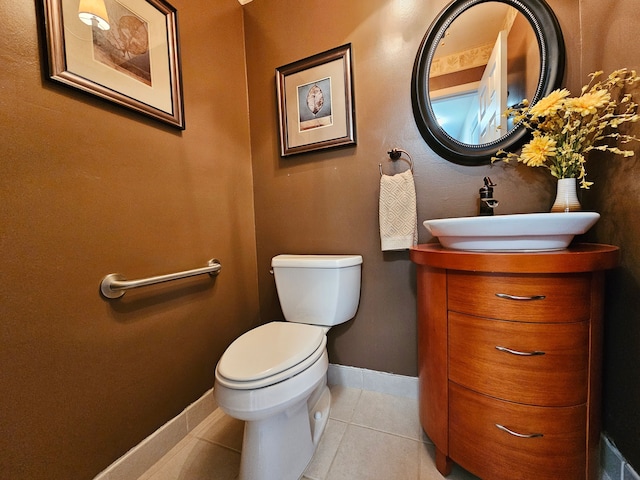 half bath featuring vanity, tile patterned flooring, baseboards, and toilet