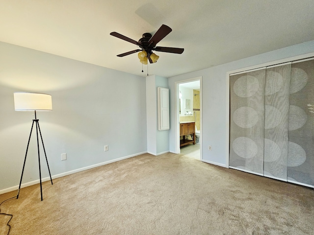 unfurnished bedroom featuring carpet floors, baseboards, and ensuite bathroom