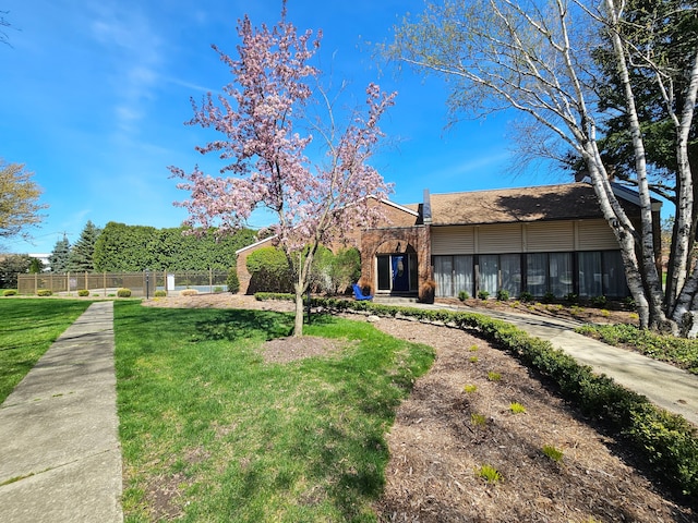 single story home with fence, a front lawn, and brick siding