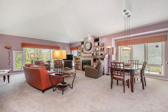 carpeted living area with a tiled fireplace, a notable chandelier, and lofted ceiling