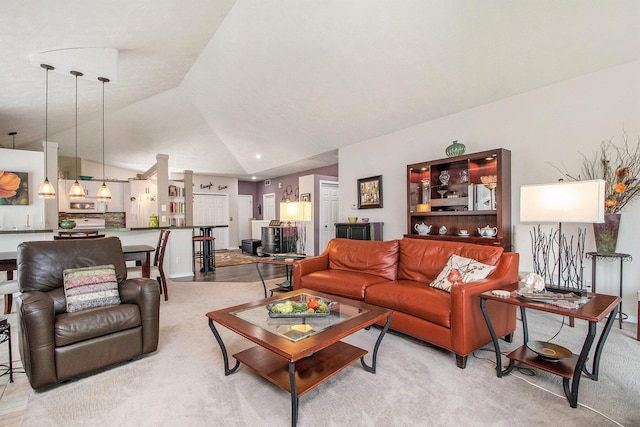 living area with high vaulted ceiling and light carpet
