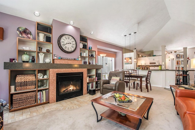 carpeted living room with a fireplace and lofted ceiling
