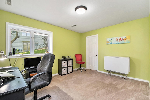 office area featuring baseboards, visible vents, and light carpet
