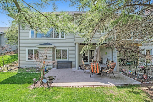 rear view of property featuring a lawn and a patio
