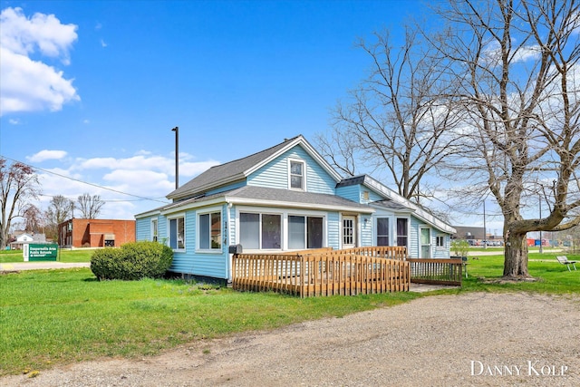 114 E St, Coopersville, MI 49404 - bungalow-style house with a front lawn, roof with shingles, and a wooden deck