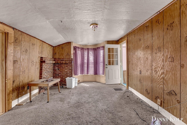 114 E St, Coopersville, MI 49404 - interior space with wooden walls, a textured ceiling, vaulted ceiling, and carpet floors