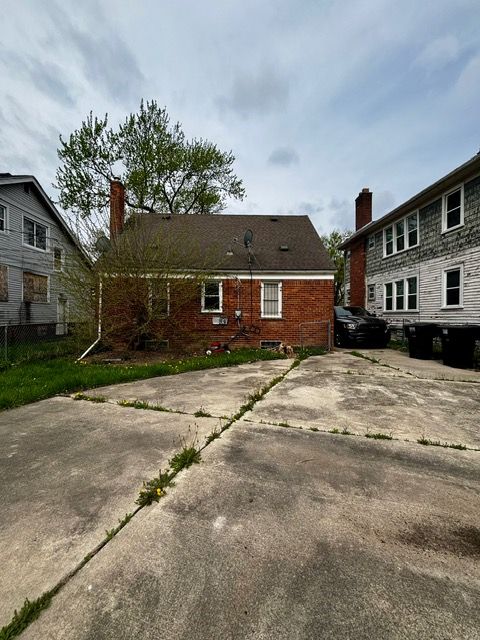 back of property with fence and a chimney