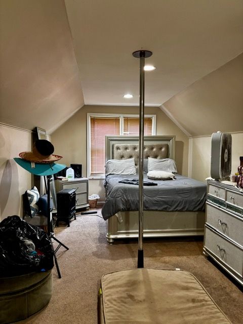 carpeted bedroom with lofted ceiling