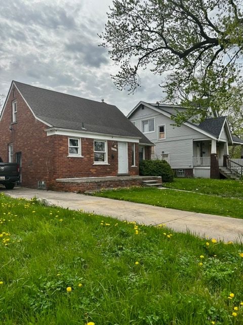 view of front of house featuring a front lawn and brick siding