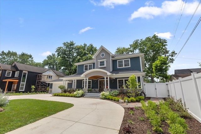 114 Bernstadt St, Novi, MI 48377 - view of front of home featuring a porch, fence, curved driveway, and a gate