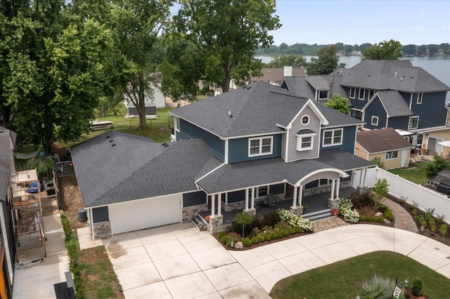 114 Bernstadt St, Novi, MI 48377 - view of front facade with fence, covered porch, stone siding, roof with shingles, and driveway