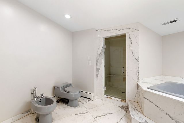 362 Keswick Rd, Bloomfield Hills, MI 48304 - full bath featuring visible vents, marble finish floor, a shower stall, a baseboard heating unit, and a bidet