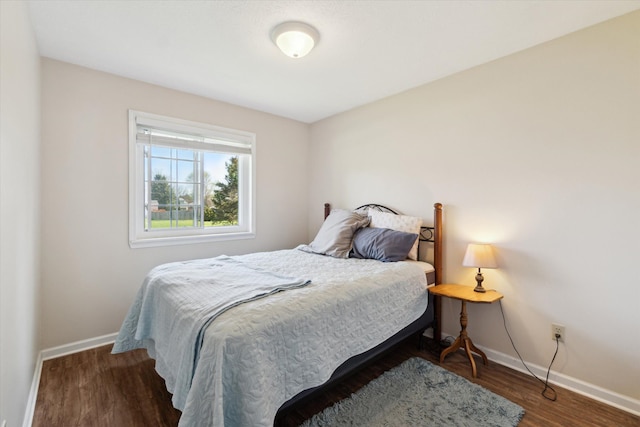 bedroom featuring baseboards and wood finished floors
