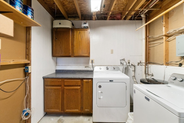 clothes washing area featuring cabinet space and washer and clothes dryer