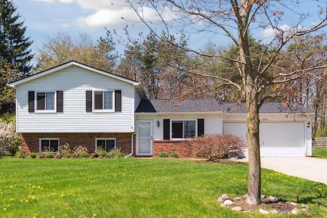 tri-level home with a garage, driveway, brick siding, and a front yard