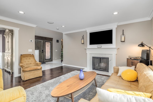 living area with crown molding, recessed lighting, wood finished floors, and a fireplace