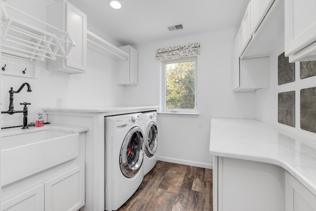 laundry area with washing machine and dryer, dark wood finished floors, recessed lighting, a sink, and cabinet space