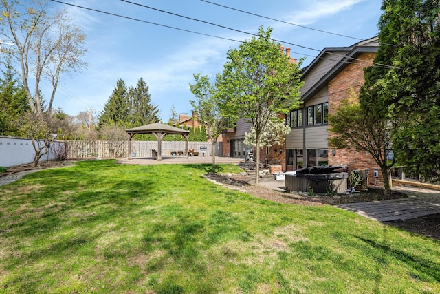 view of yard featuring a gazebo, a fenced backyard, a hot tub, and a patio