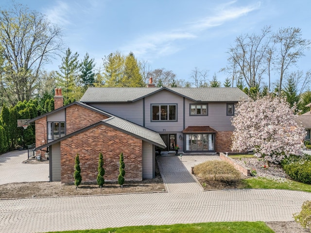 traditional-style home featuring brick siding and a chimney