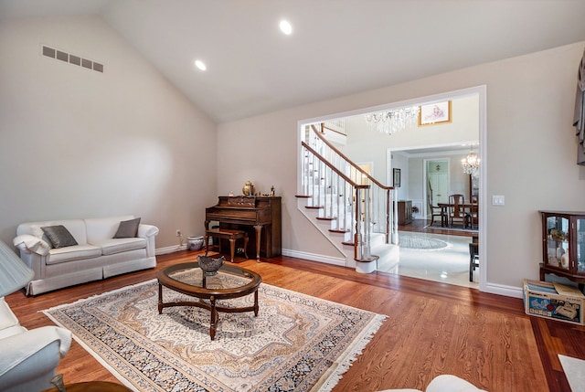 2832 Croftshire Ct, Rochester, MI 48306 - living room with visible vents, an inviting chandelier, stairs, wood finished floors, and vaulted ceiling