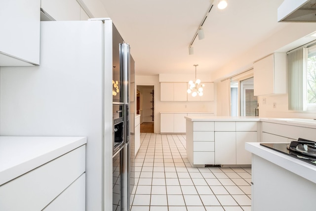 kitchen with freestanding refrigerator, a chandelier, light tile patterned floors, light countertops, and decorative light fixtures