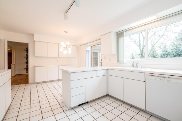 kitchen with white dishwasher, a sink, a chandelier, and light tile patterned floors