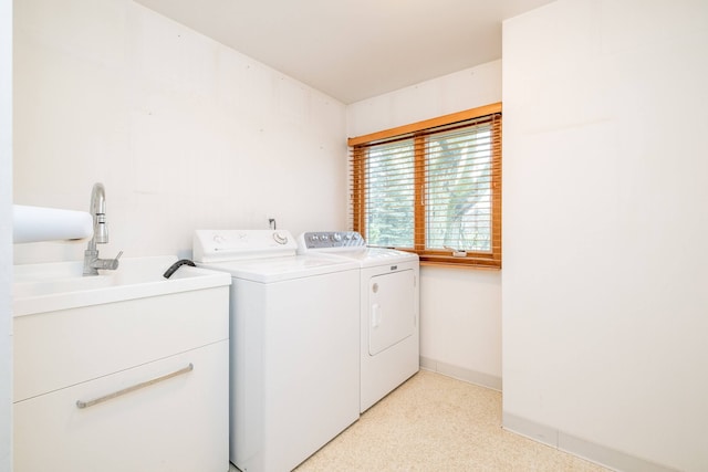 clothes washing area featuring separate washer and dryer and baseboards