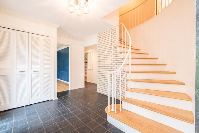 stairway with crown molding, a chandelier, and baseboards