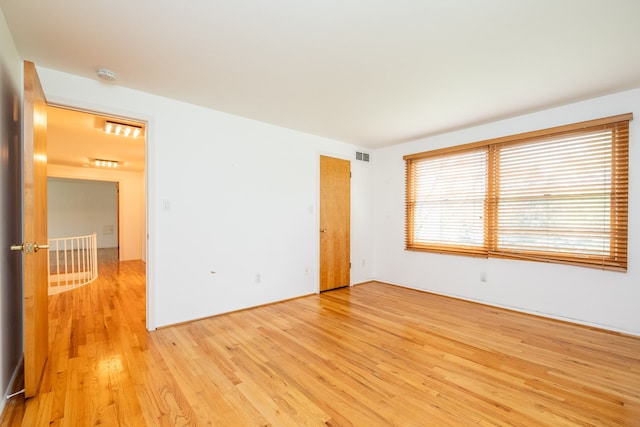 spare room with light wood-style floors and a smoke detector